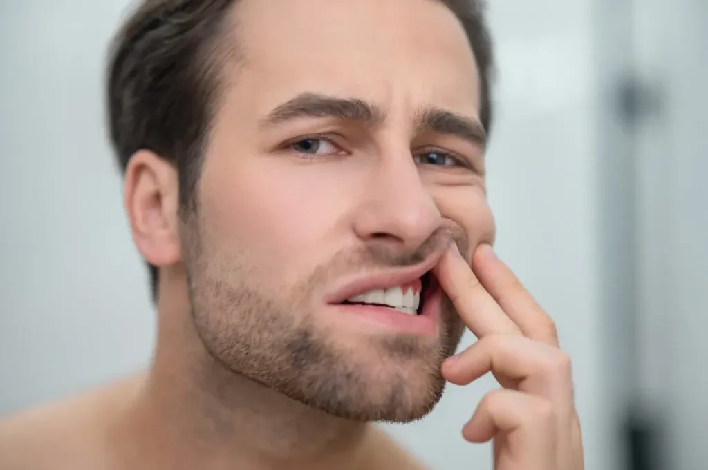 2️⃣ Man checking swollen gums in mirror – Gum Disease Treatment at SpringLake Dental Woodland, CA