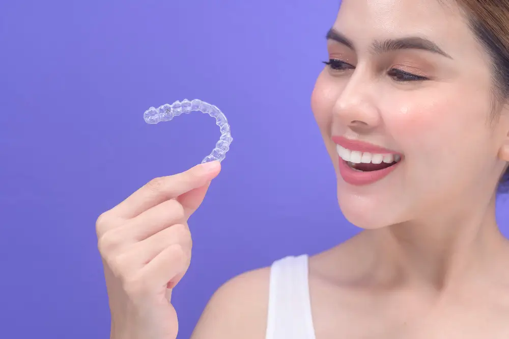 Invisalign clear aligners in Woodland CA — patient holding aligner tray at SpringLake Dental